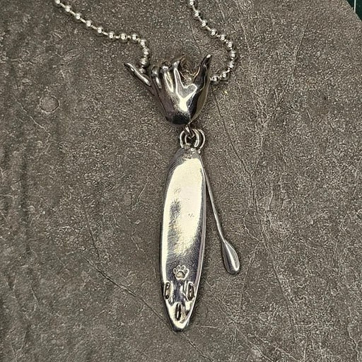 Back side of sterling silver SUP board pendant with paddle and Shaka hand bail – handcrafted surf jewelry by Snow Cat Jewelry