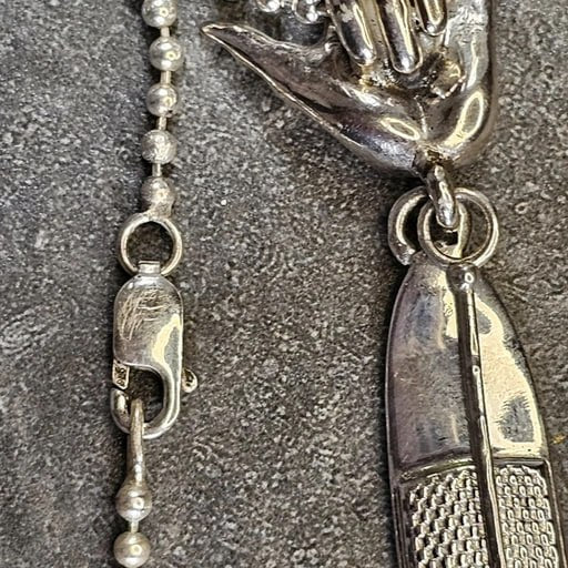 Close-up of sterling silver Shaka hand bail and SUP paddleboard pendant with chain – handcrafted surf jewelry by Snow Cat Jewelry