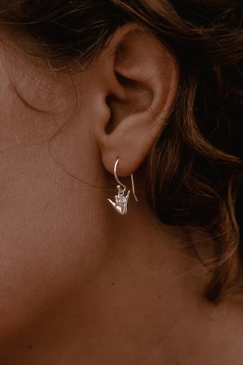 Woman wearing 925 sterling silver Shaka hook earring – surf symbol jewelry from Snow Cat Jewelry