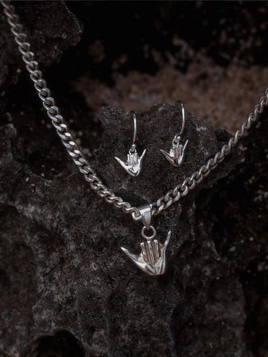Sterling silver Shaka jewelry set featuring pendant and hook earrings on volcanic rock – surf-inspired design by Snow Cat Jewelry