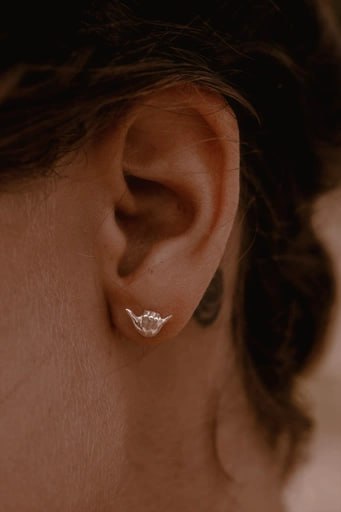 Sterling silver Shaka stud earring in ear – surf style jewelry by Snow Cat