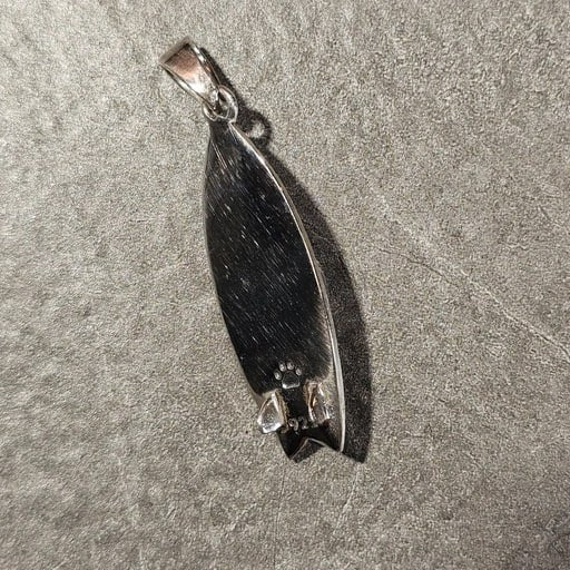 Angled back view of sterling silver Barong surfboard pendant with 925 stamp and fish tail shape – handcrafted surf jewelry by Snow Cat Jewelry