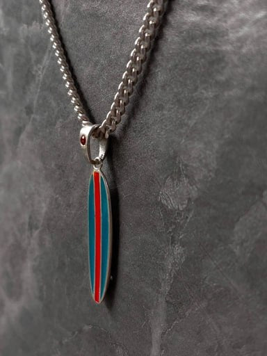 Angled view of Reef Runner surfboard pendant with red center stripe and teal enamel – 925 silver longboard necklace with red gemstone by Snow Cat Jewelry