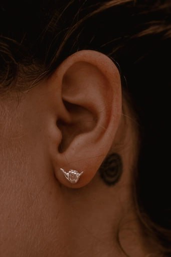 terling silver Shaka stud earring in ear – surf style jewelry by Snow Cat